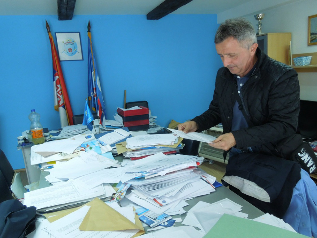 Миодраг Антониќ ги прегледува судските документи во канцеларијата на Полицискиот синдикат на Србија во Лозница, јули 2015 / Фото: Мирко Рудиќ 