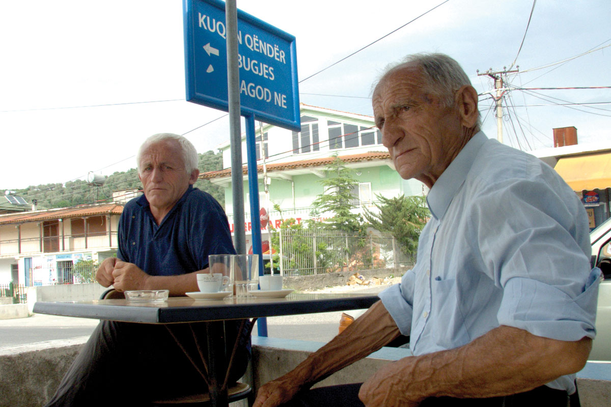 Серан Брахо, 84-годишен муслиман и неговиот пријател Трифон Ранџа, 54-годишен православен христијанин, во бар во селото Куќан. Фото: Владимир Карај